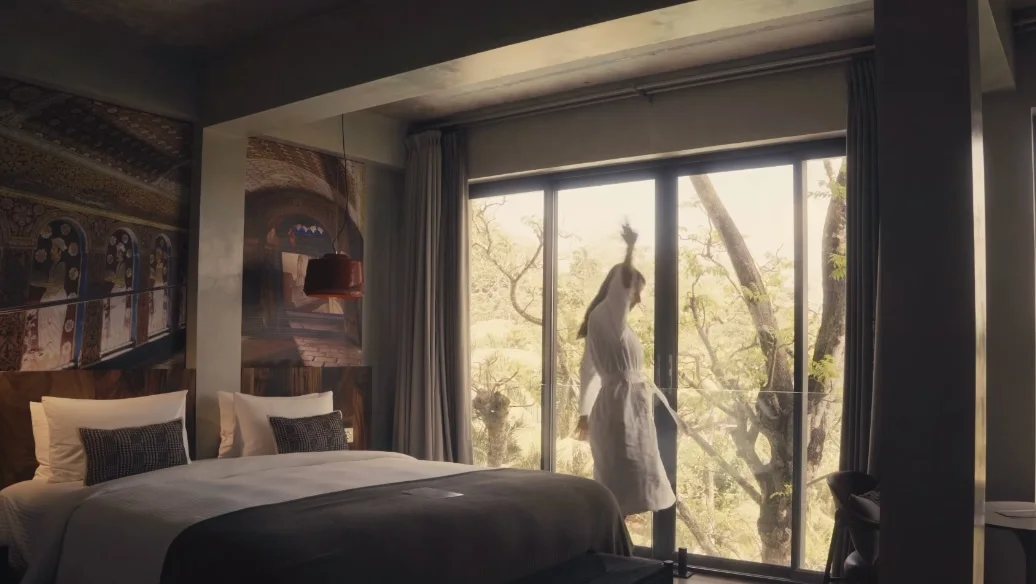 Original Instagram reel from NiiRA: the bedroom with the bed and a guest in a white robe at the window.